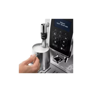 Une main fait mousser le lait avec une brosse à vapeur sur la DELONGHI FEB3535.SB, une machine à espresso dotée d'un écran numérique et de commandes à boutons.