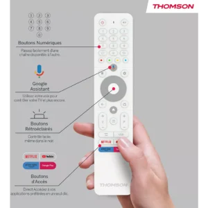 Main tenant une télécommande de télévision THOMSON 32HA4M44, comportant des boutons étiquetés pour Google Assistant, Netflix, rétro et des fonctions d'accès.