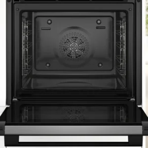 Four encastrable BOSCH HBA4720B3F ouvert et vide avec la porte vers le bas dans une cuisine moderne avec un sol en bois clair et un coin repas.