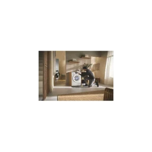 Une personne est agenouillée devant un lave-linge MIELE dans une buanderie moderne et ensoleillée, avec le sèche-linge MIELE TSC643WP à proximité.