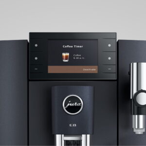 Gros plan d'une machine à café JURA E8 COSMIC BLACK (ED), dont l'écran affiche un café programmé à 6h30.