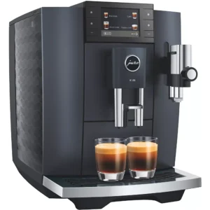 La machine à café JURA E8 COSMIC BLACK (ED) peut préparer deux expressos à la fois et dispose d'un panneau de commande numérique moderne au-dessus des becs verseurs.