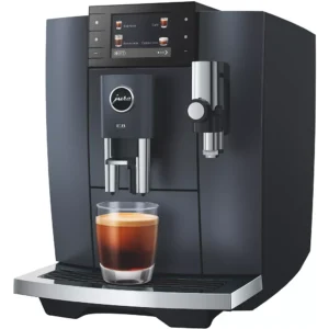 La JURA E8 COSMIC BLACK (ED) prépare une tasse de café frais dans un verre placé sur son plateau.
