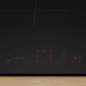 La table de cuisson à induction BOSCH PVW89BHC1E en verre noir est dotée de commandes numériques rouges et s'harmonise avec tous les comptoirs en bois.
