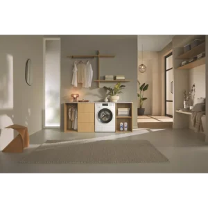 Buanderie moderne avec le lave-linge MIELE WSG883WCS, des vêtements suspendus, des plantes, des étagères et un éclairage naturel doux.