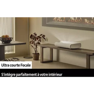 Un projecteur SAMSUNG SP-PLU7D blanc est placé sur un banc en bois, projetant une image sur un mur dans une pièce épurée et minimaliste.
