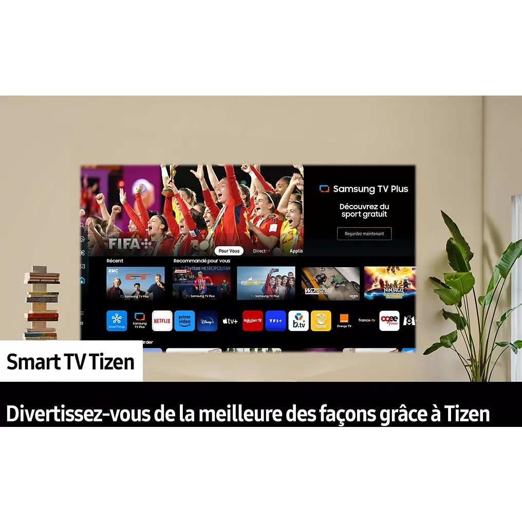 Une smart TV SAMSUNG SP-PLU7D fixée au mur diffuse des applications en continu et un match de football, avec des livres et une plante à proximité.