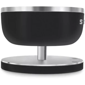 Le SMEG KSC01BLMWW est un appareil électronique élégant, noir et argenté, avec une base et un bouton ronds, vu de côté.