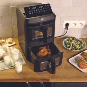 Un comptoir de cuisine avec un FRIFRI AIRFRYER DUO SLIM, du poulet cuit, du saumon, des accompagnements et des desserts.