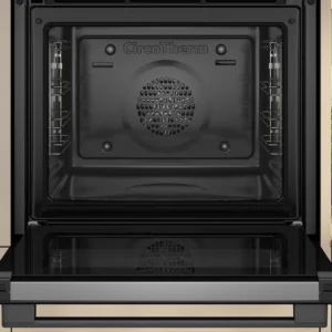 Ouvrez le four NEFF B2ACJ7AG0 aux lignes épurées, arborant le logo CircoTherm, placé à côté d'un comptoir de cuisine garni d'herbes, de noix et d'une planche à découper en bois.