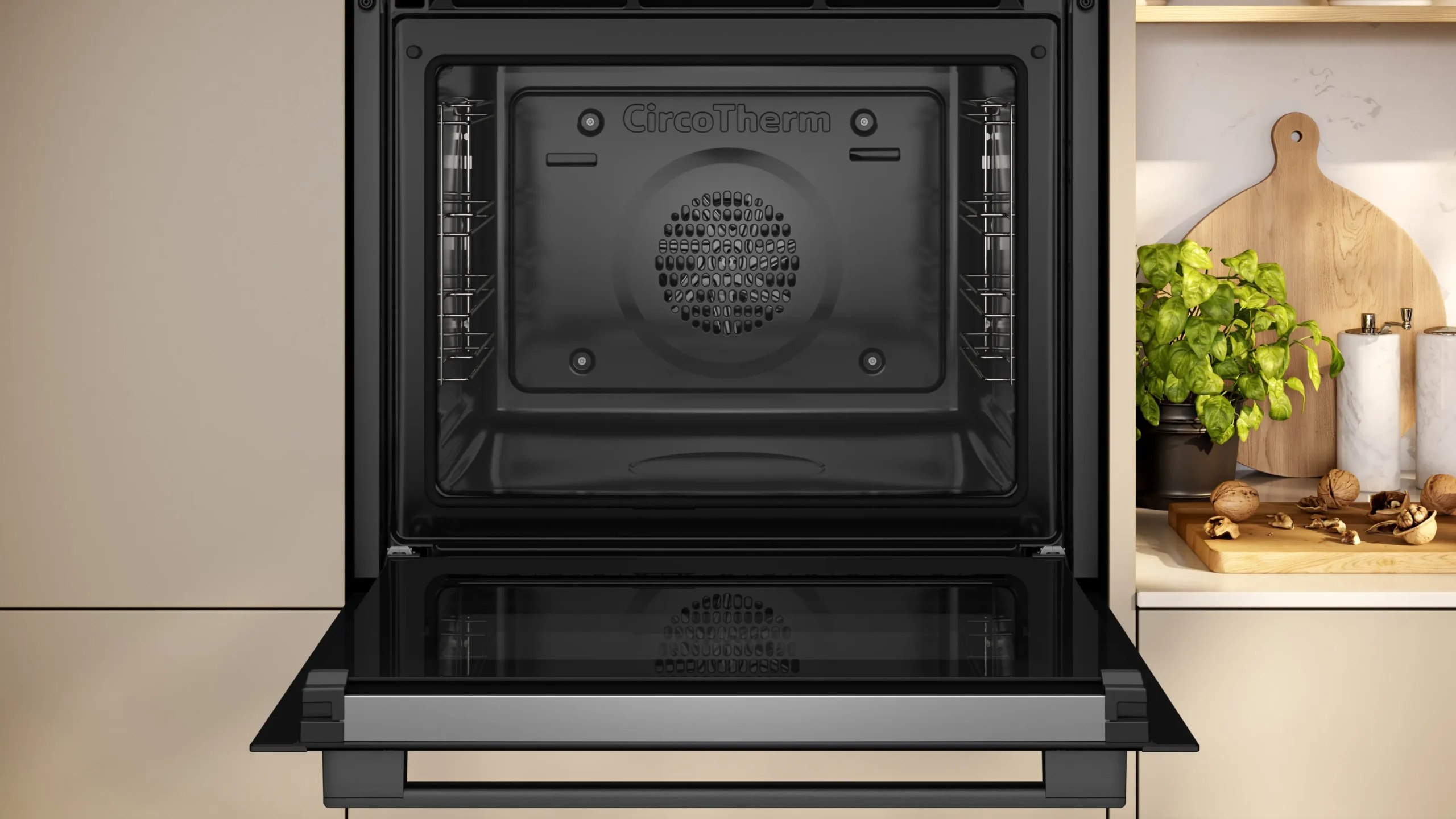 Ouvrez le four NEFF B2ACJ7AG0 aux lignes épurées, arborant le logo CircoTherm, placé à côté d'un comptoir de cuisine garni d'herbes, de noix et d'une planche à découper en bois.