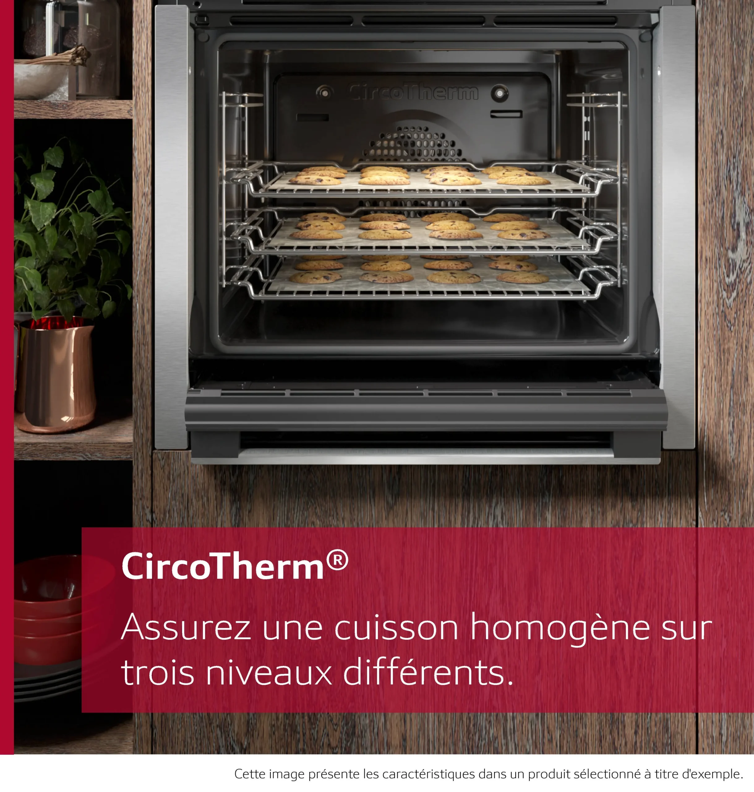 Le four NEFF B2ACJ7AG0, avec trois plateaux de biscuits cuisant uniformément à l'intérieur, est posé à côté d'une plante sur un comptoir en bois.