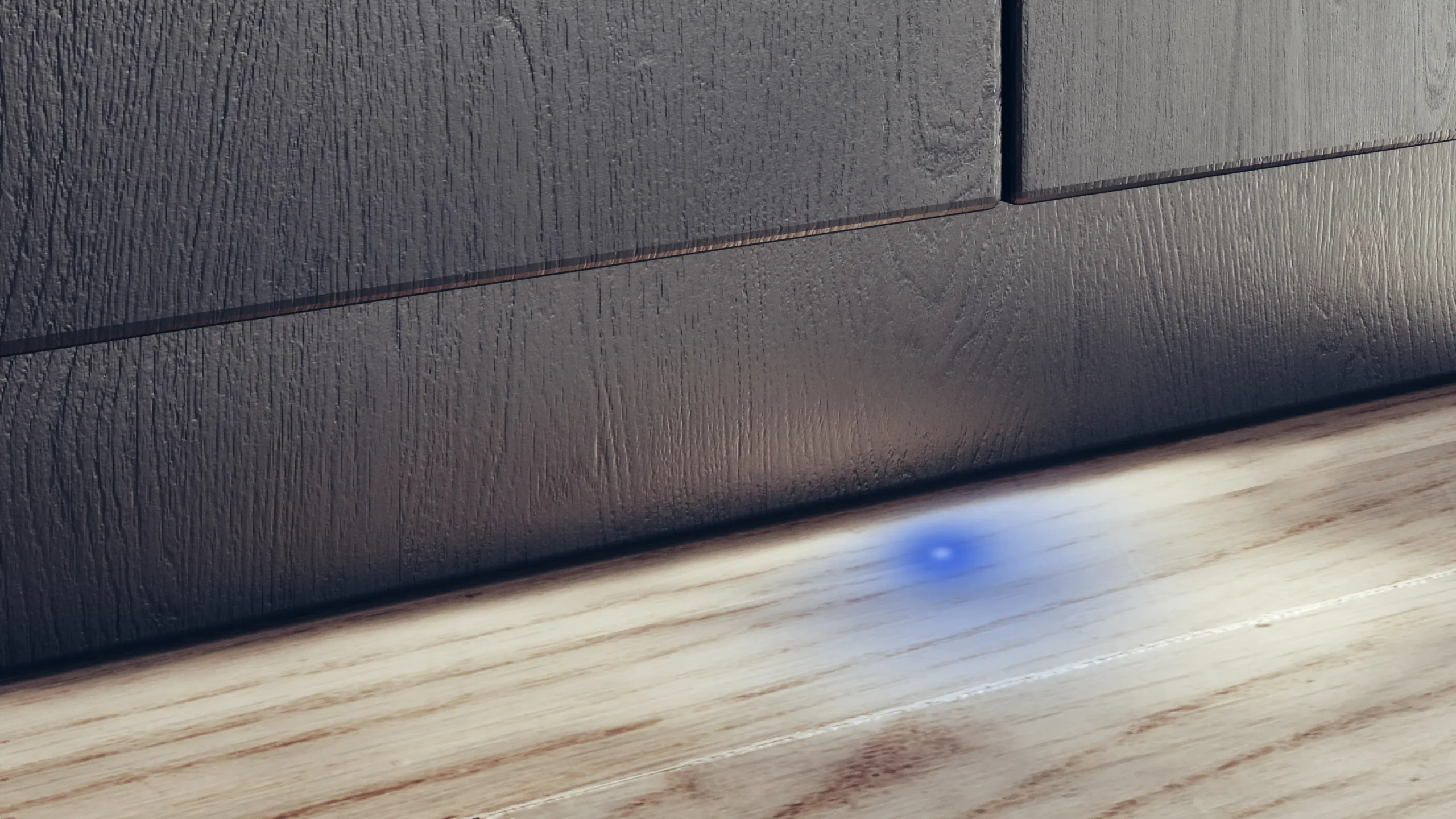 Un voyant bleu situé à la base d'un meuble en bois au-dessus d'un plancher en bois signale que le lave-vaisselle SIEMENS SN63EX05ME fonctionne silencieusement derrière les portes fermées.