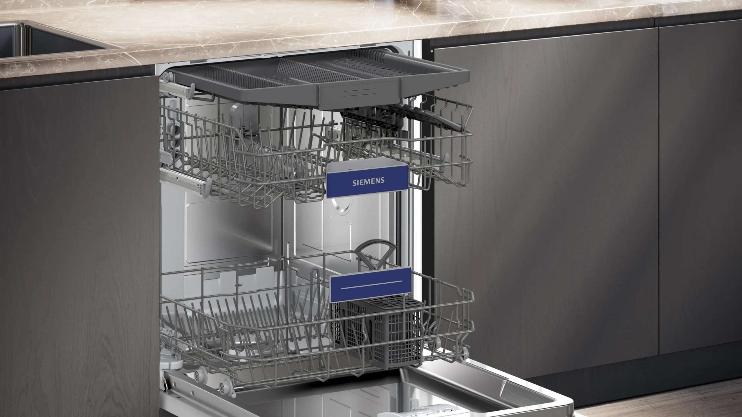 Lave-vaisselle SIEMENS SN55ES12CE (Copie) ouvert avec des paniers supérieurs et inférieurs vides sous un comptoir en marbre dans une cuisine moderne.