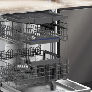 Ouvrez le lave-vaisselle moderne SIEMENS SN65Z804CE, équipé de trois paniers coulissants vides, situé sous un plan de travail en marbre dans une cuisine élégante.