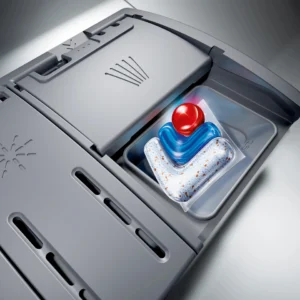 Gros plan sur le compartiment à détergent d'un lave-vaisselle SIEMENS SN65Z804CE contenant une dosette de détergent.