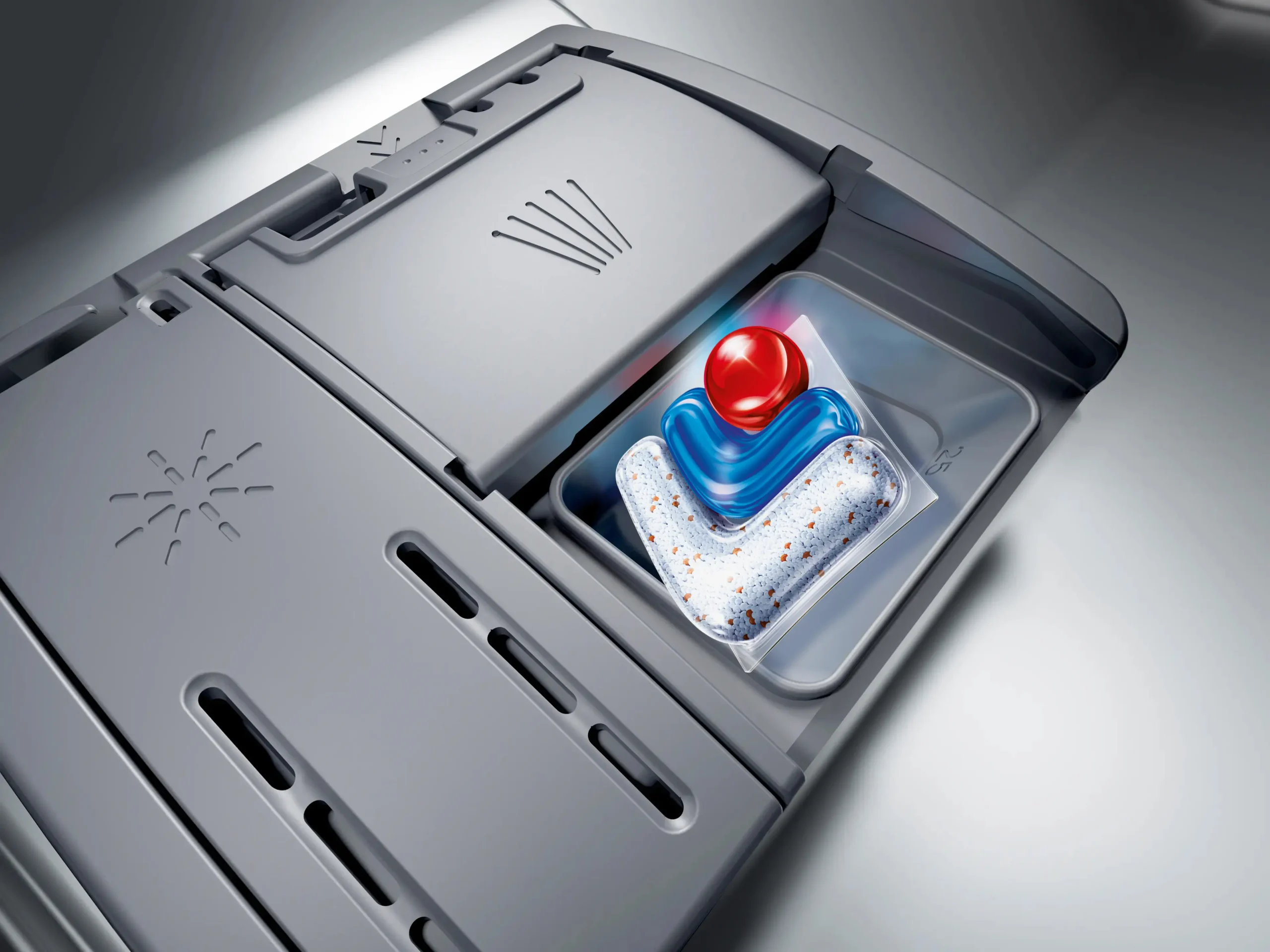 Gros plan sur le compartiment à détergent d'un lave-vaisselle SIEMENS SN65Z804CE contenant une dosette de détergent.