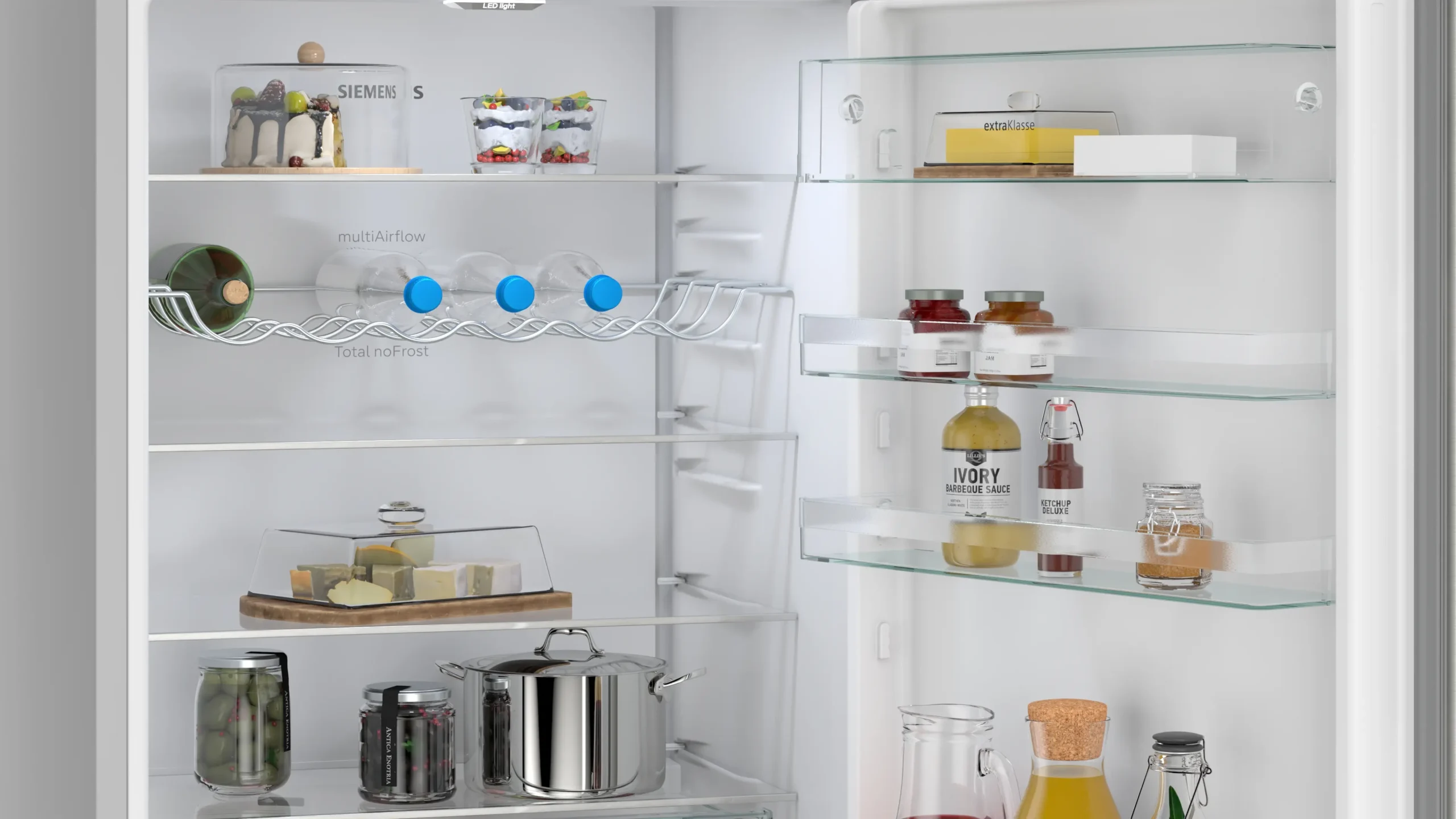 Ouvrez le réfrigérateur SIEMENS KG49NEICU pour découvrir des boissons, du fromage, des bocaux et des condiments bien rangés sur les étagères et dans la porte.