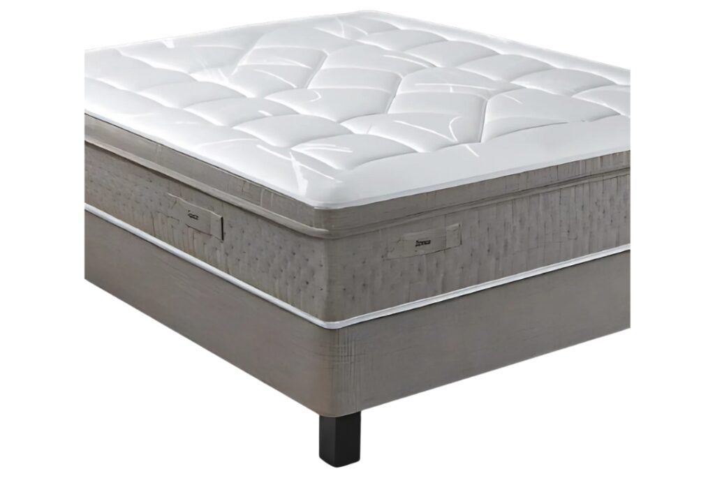 Le matelas EPEDA GALACTIQUE 2 160x200 présente un design moderne et épais avec un dessus matelassé blanc et est placé sur un sommier tapissier avec des pieds noirs.