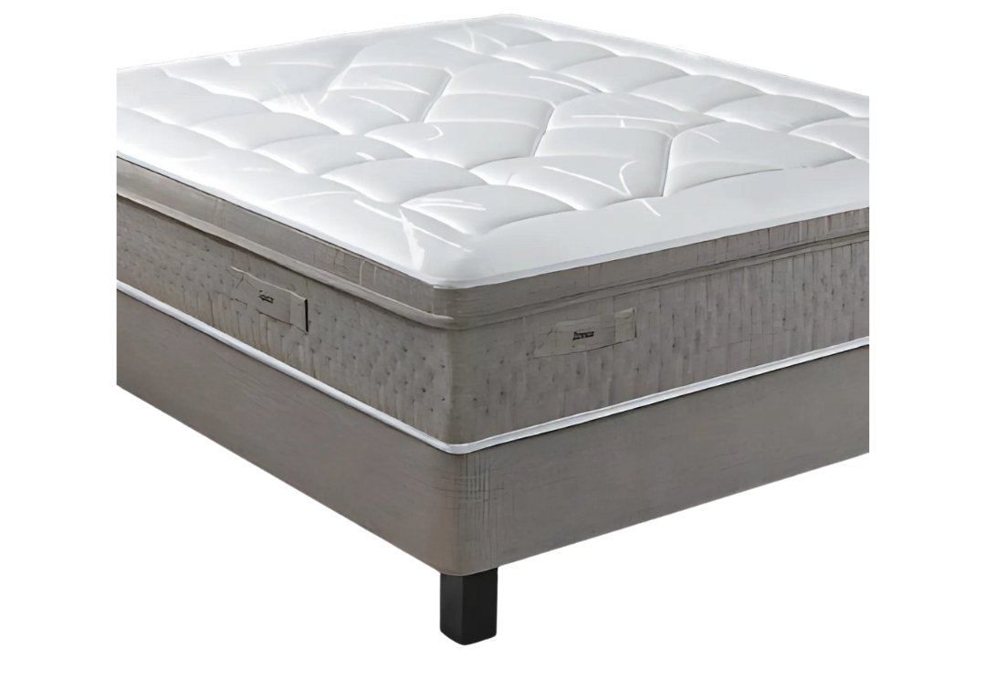 Le matelas EPEDA GALACTIQUE 2 160x200 présente un design moderne et épais avec un dessus matelassé blanc et est placé sur un sommier tapissier avec des pieds noirs.