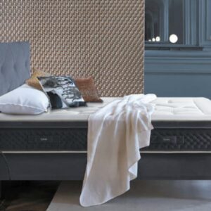 Le lit EPEDA PERSÉIDES 2 160x200, avec ses oreillers et sa couverture, ajoute du confort à une chambre élégante aux murs texturés et bleus.