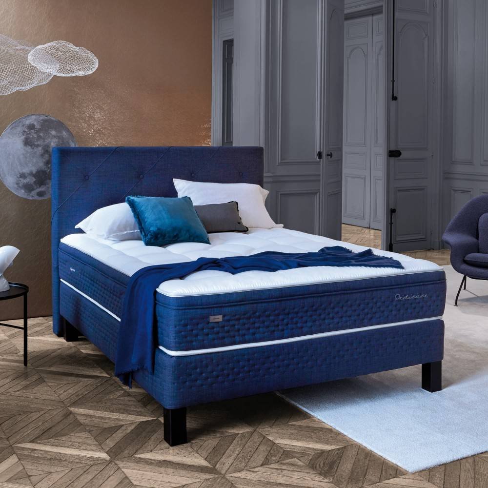 Chambre à coucher moderne avec un lit capitonné EPEDA PERSÉIDES 2 160x200 bleu, une literie blanche et des coussins décoratifs sur un sol en bois.