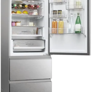 Le réfrigérateur HAIER HTW5618ENMG, avec les deux portes ouvertes, révèle des étagères remplies d'aliments, de boissons et de desserts.
