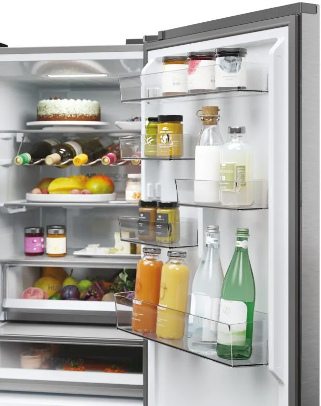 Le réfrigérateur HAIER HTW5618ENMG est rempli d'aliments.