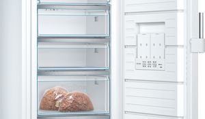 Ouvrez le congélateur vertical BOSCH GSN54EWCV, doté de trois tiroirs transparents, en plaçant deux sacs de pain dans le tiroir du bas.