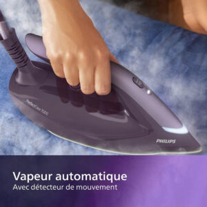 Repassage à la main d'un tissu bleu avec le fer à vapeur PHILIPS PSG7150-30 ; le texte indique "Vapeur automatique, Avec détecteur de mouvement.