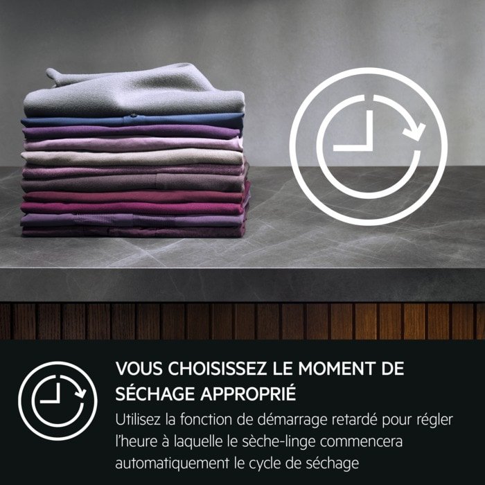 Une pile de vêtements soigneusement pliés, accompagnée d'une icône d'horloge et d'un texte en français sur le séchage différé, illustre la précision et l'efficacité de l'AEG TR81A3G6BOE en matière d'entretien du linge.