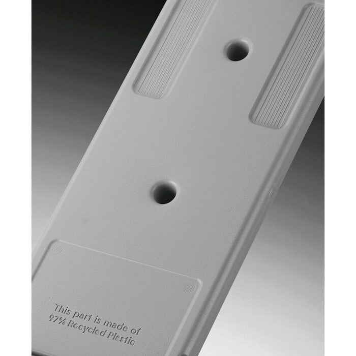 Gros plan d'une pièce en plastique gris provenant du sèche-linge AEG TR95A9B6BW, comportant deux trous et un texte en relief indiquant qu'elle est fabriquée à partir de 97 % de plastique recyclé.