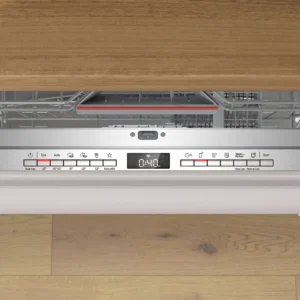 Le lave-vaisselle BOSCH SMV4EB806E avec panneau de commande visible et affichage numérique est installé sous un comptoir en bois sur un sol en bois clair.