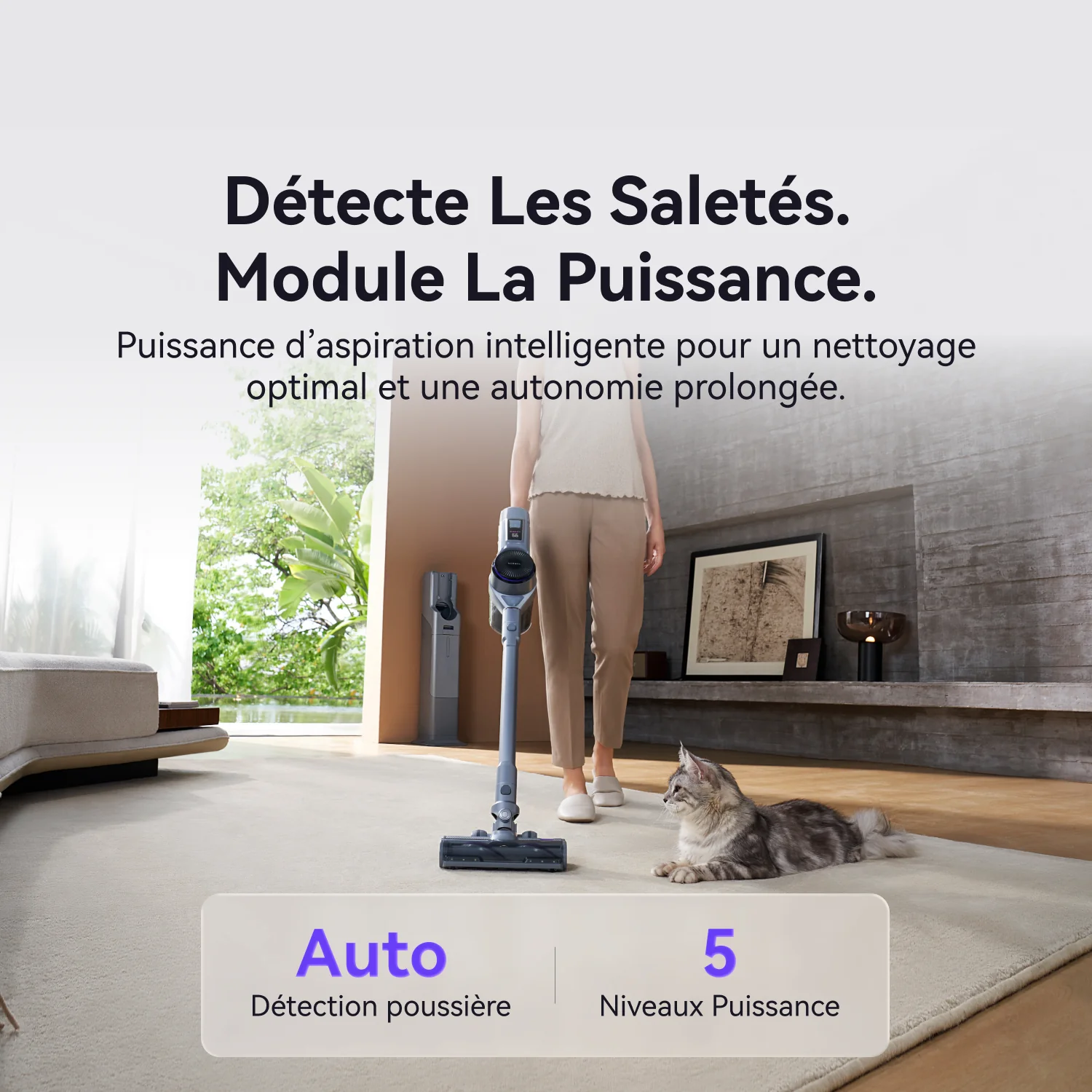 Une femme utilise l'aspirateur sans fil NARWAL pour nettoyer son salon sous le regard de son chat, mettant ainsi en valeur sa puissance d'aspiration intelligente.