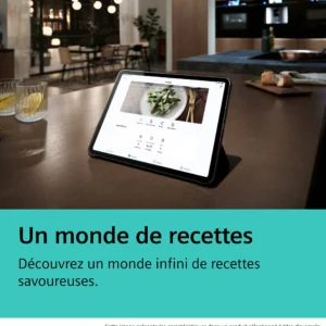 Une tablette montrant une recette est posée sur le comptoir d'une cuisine, près de verres et d'aliments, le four SIEMENS HB974GLB1 étant visible à l'arrière-plan.