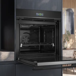 Le four encastrable SIEMENS HB974GLB1 est présenté avec sa porte ouverte dans une cuisine moderne et élégante.
