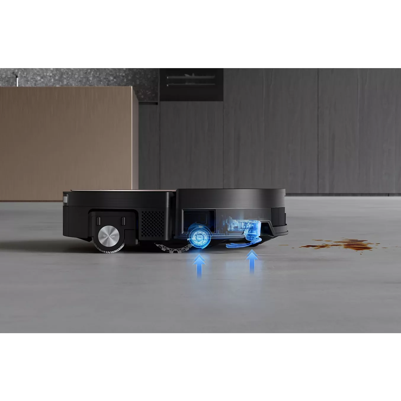 L'aspirateur robot ECOVACS X11 omni nettoie un déversement sur le sol. Les flèches bleues situées en dessous illustrent sa forte puissance d'aspiration.