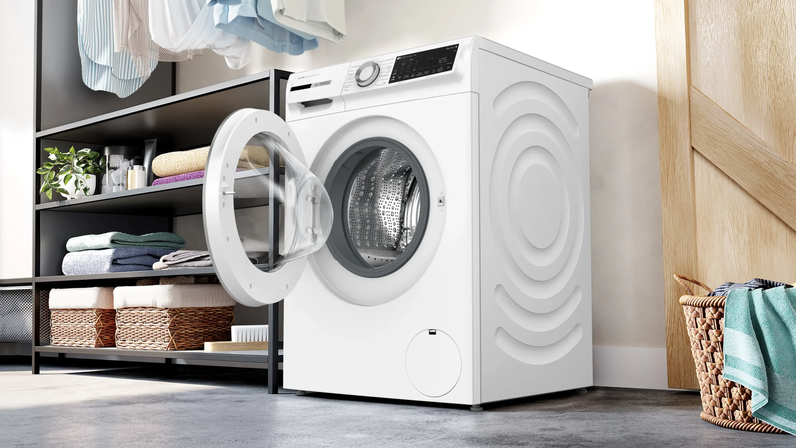 Un lave-linge moderne BOSCH WGG254FAFR (Copie) à chargement frontal avec la porte ouverte est présenté dans une buanderie avec des étagères de serviettes soigneusement pliées.