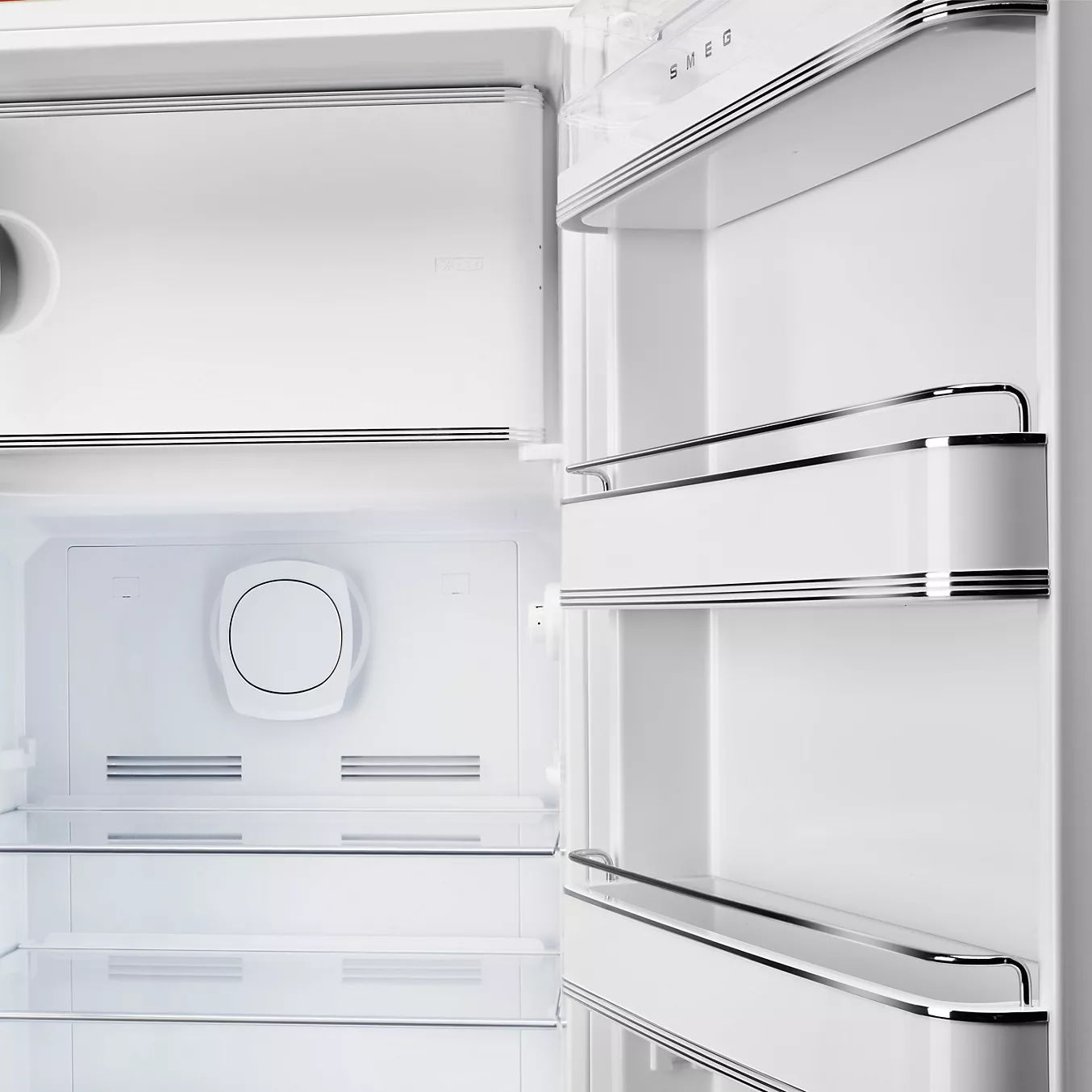 Le réfrigérateur SMEG FAB28RSBM6 est doté d'un intérieur blanc impeccable, d'étagères en verre et de compartiments de porte.