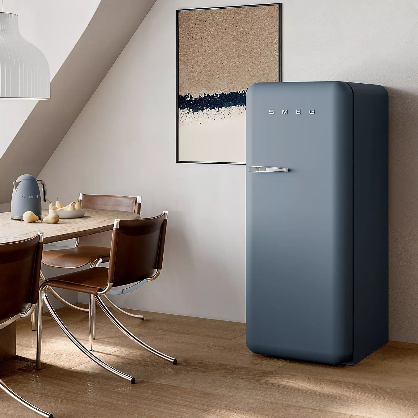 Le réfrigérateur bleu SMEG FAB28RSBM6 se trouve dans une cuisine moderne dotée d'une table en bois, de chaises et d'un tableau mural abstrait.