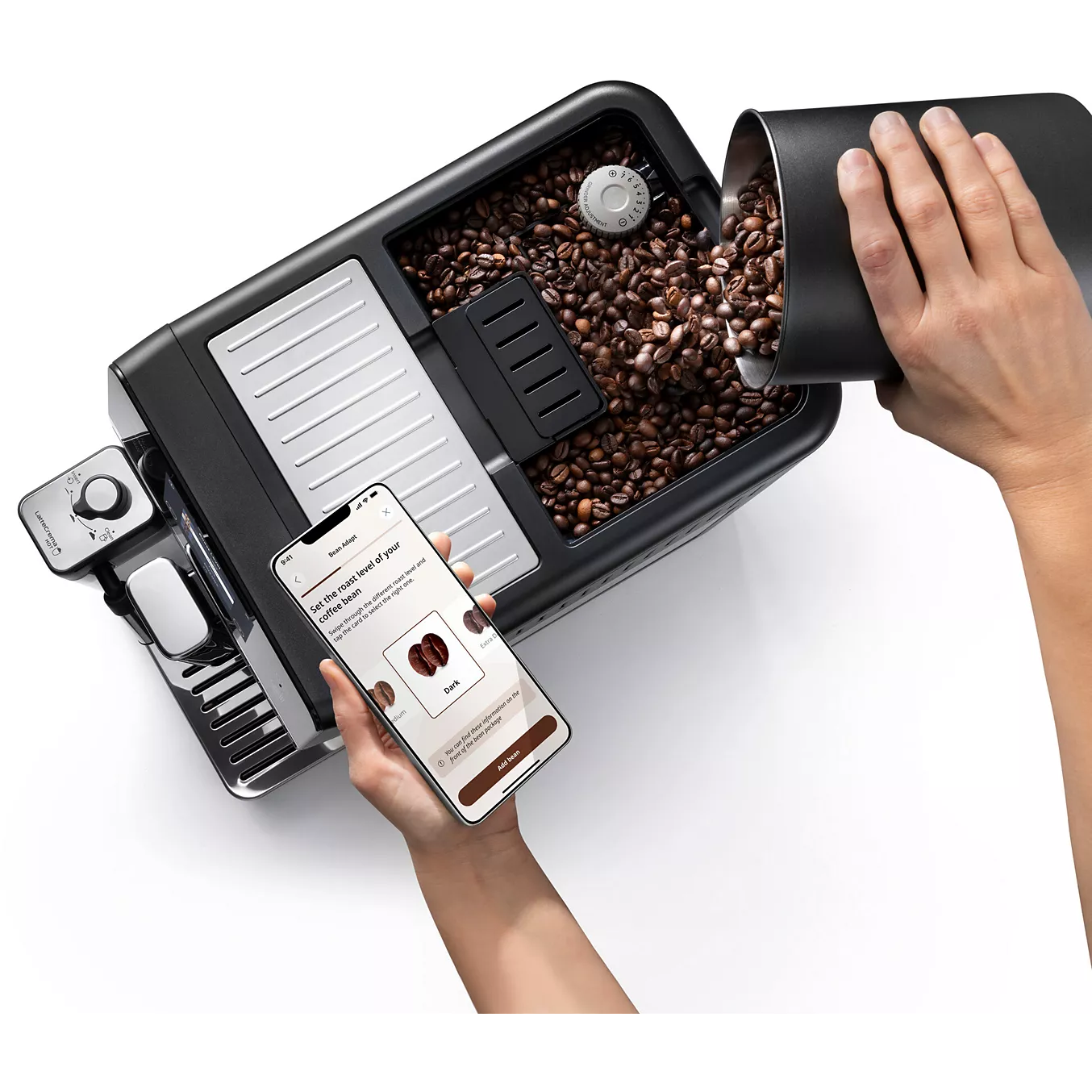 Une personne verse des grains de café dans la machine à café DELONGHI ELETTA EXPLORE ECAM470.85.MB et la contrôle à l'aide d'une application pour smartphone.