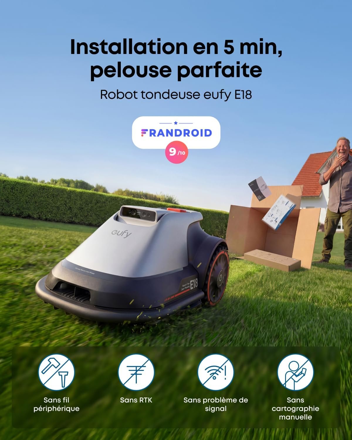 Un homme sourit tout en parlant au téléphone tandis qu'un robot de tonte EUFY E18 coupe la pelouse soigneusement taillée, son boîtier étant visible à proximité.