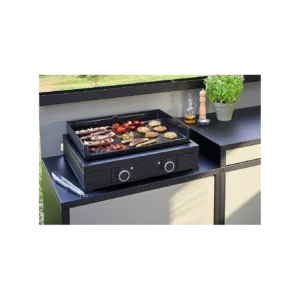 La plancha FORGE ADOUR MODERN E60 AN grille des brochettes, des légumes et de la viande sur une élégante plancha de table noire, rendant la cuisine en plein air facile et élégante avec des herbes fraîches en pot.