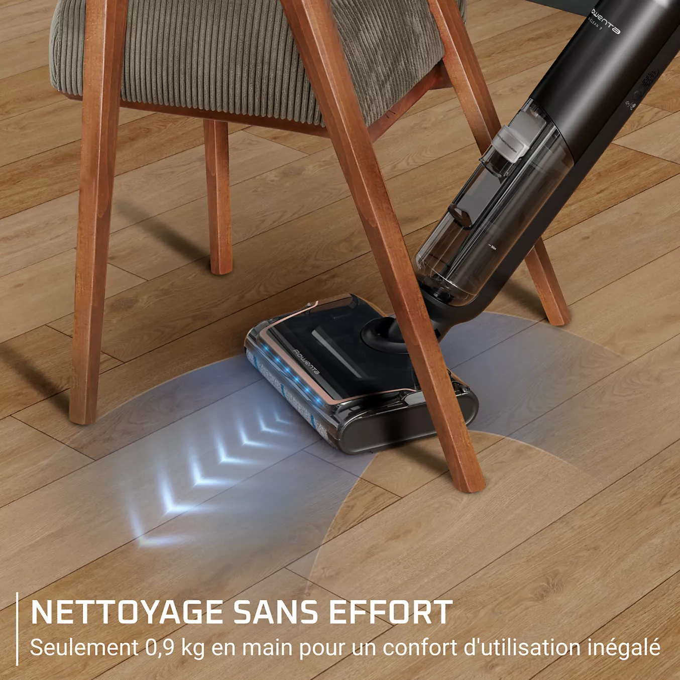 L'aspirateur ROWENTA GZ5736E0 se déplace en douceur sous une chaise sur un sol en bois, avec des effets lumineux qui mettent en évidence la précision de son parcours de nettoyage.