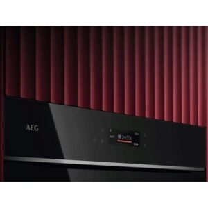 Gros plan du panneau de commande de l'AEG TX7PB631SB doté d'un affichage numérique sur fond rouge nervuré.