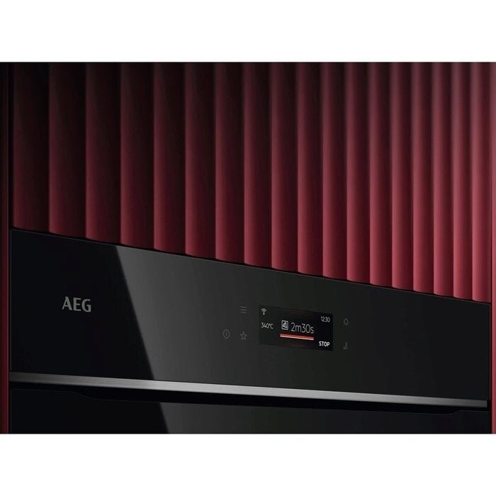 Gros plan du panneau de commande de l'AEG TX7PB631SB doté d'un affichage numérique sur fond rouge nervuré.