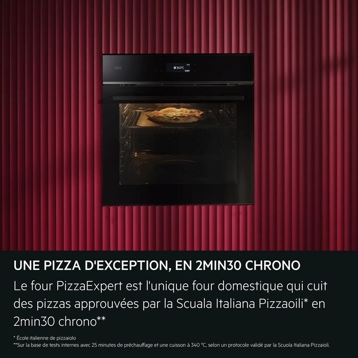 Un four noir moderne contenant une pizza se trouve à côté d'un mur rouge à rayures, tandis que le sèche-linge AEG TX7PB631SB apporte un style supplémentaire à cette cuisine contemporaine.