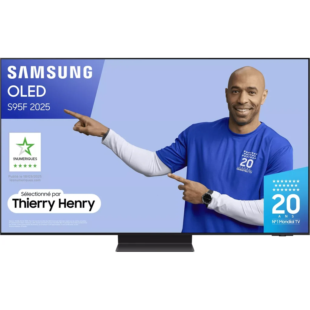 Un homme en chemise bleue montre un téléviseur Samsung affichant le modèle SAMSUNG TQ55S95F, avec des logos visibles et le texte "Thierry Henry" sur l'écran.