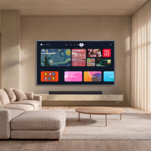Ce salon moderne est équipé d'un téléviseur SAMSUNG TQ83S95H fixé au mur, qui met en avant les applications de streaming, au-dessus d'un canapé modulable beige.