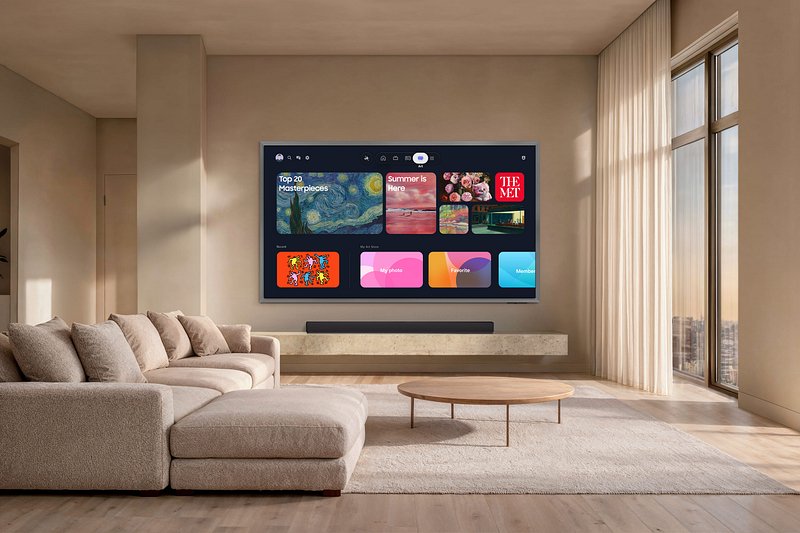 Ce salon moderne est équipé d'un téléviseur SAMSUNG TQ83S95H fixé au mur, qui met en avant les applications de streaming, au-dessus d'un canapé modulable beige.